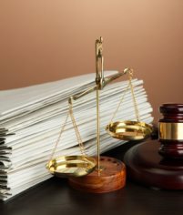 Golden scales of justice, gavel and folders on brown background